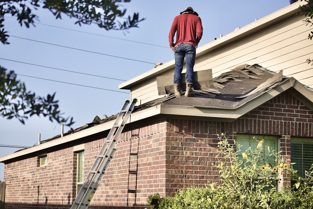 Roofing contractor inspecting storm damage on residential roof